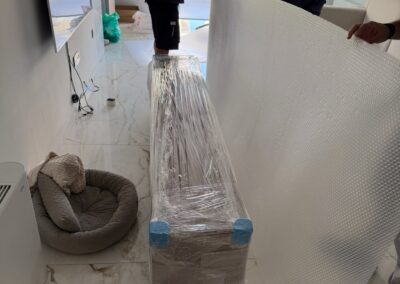 Ομάδα επαγγελματιών συσκευάζει προσεκτικά τα έπιπλα για ασφαλή μεταφορά.